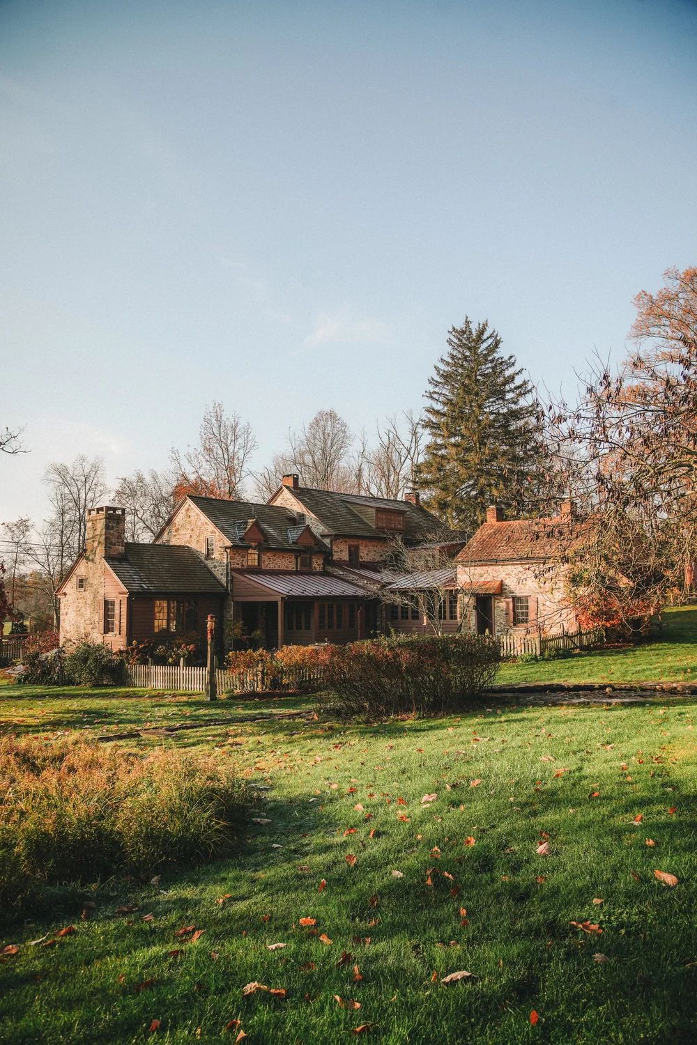 The farmhouse and outbuildings across an open field in autumn