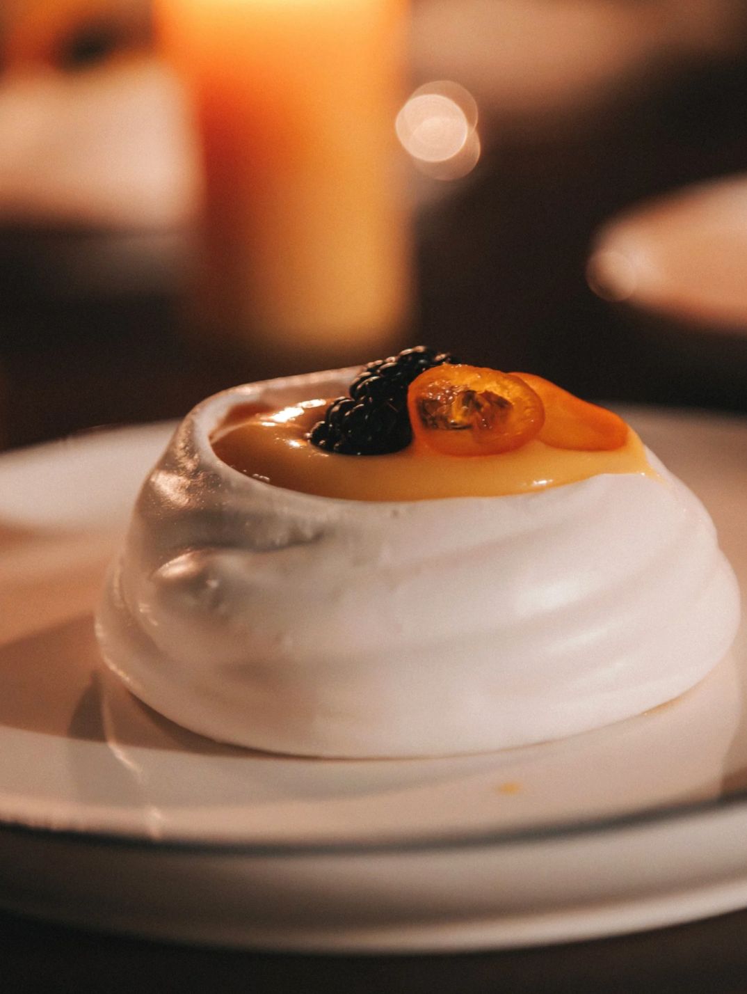 A plated dessert lit by candlelight